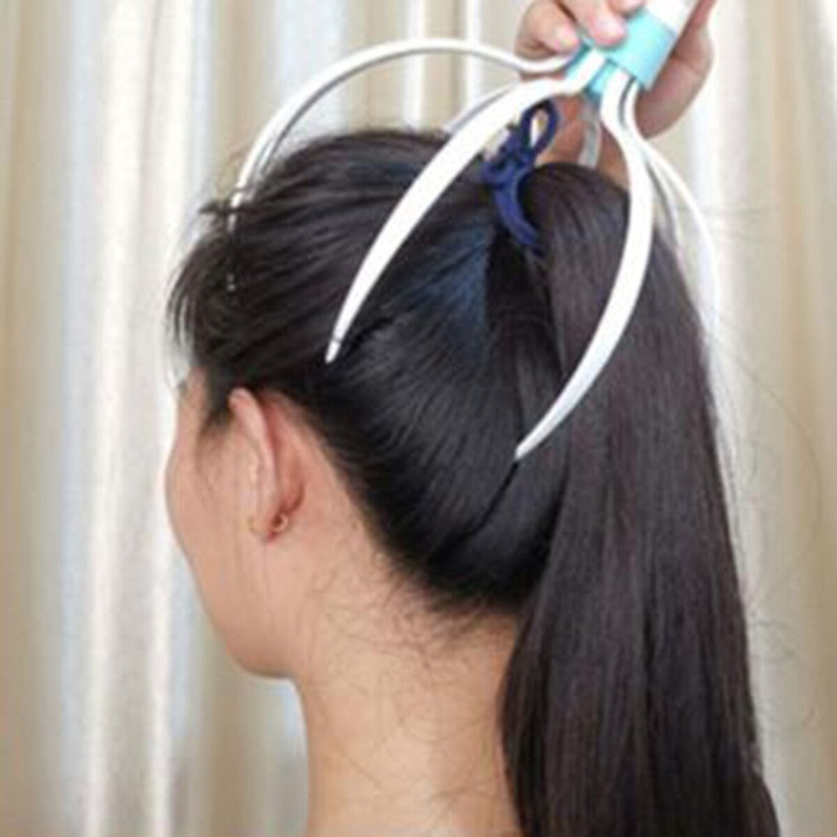 Masajeador de cabeza eléctrico usado sobre el pelo recogido